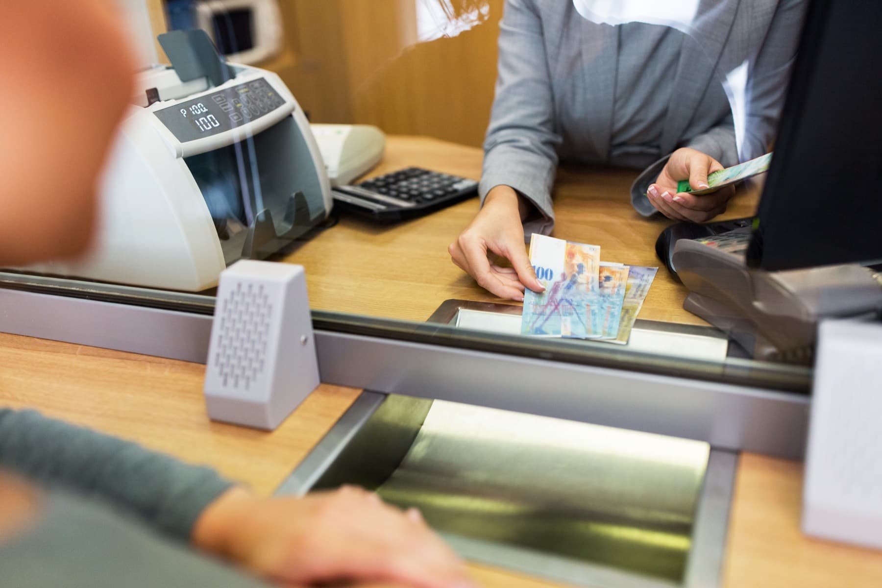 Banknotes passed across a service counter during a currency exchange